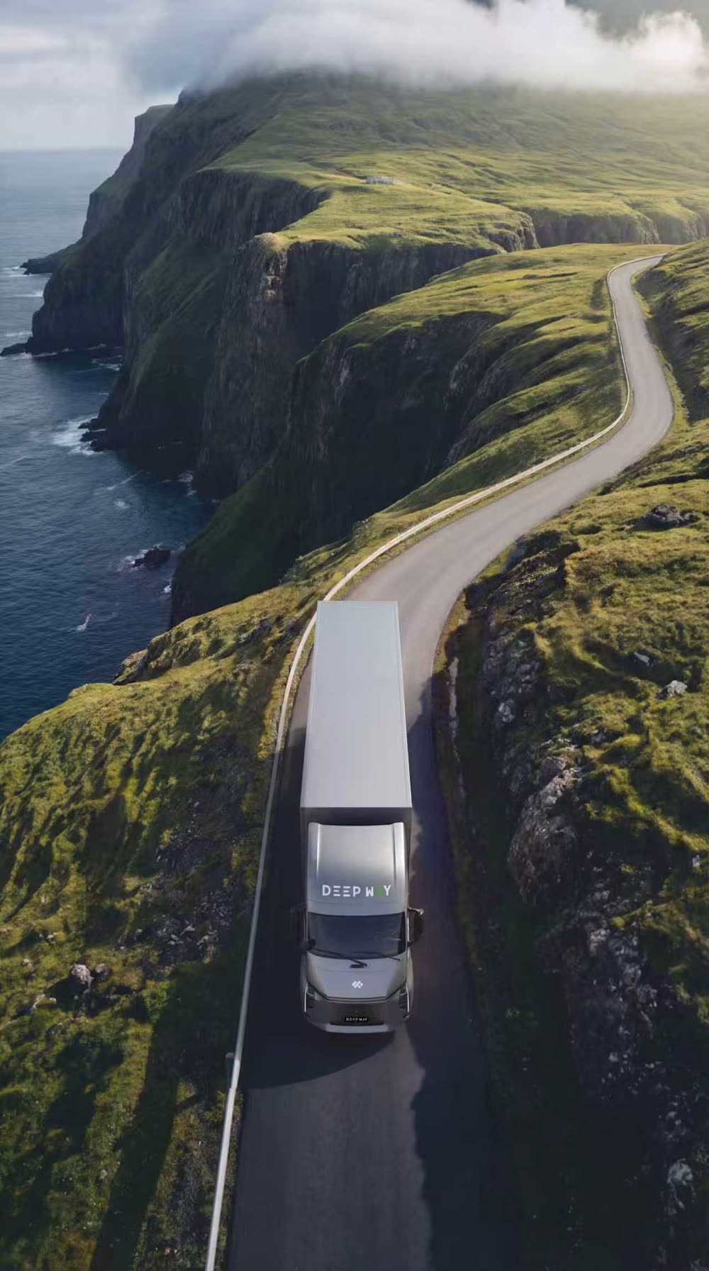 Aerial view of a Deepway Star on a winding coastal road between green cliffs